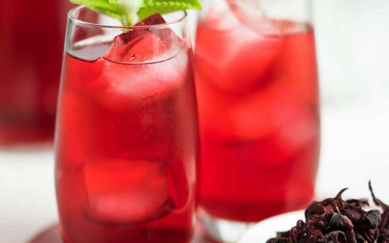 Refreshing iced hibiscus tea in tall glasses with mint garnish
